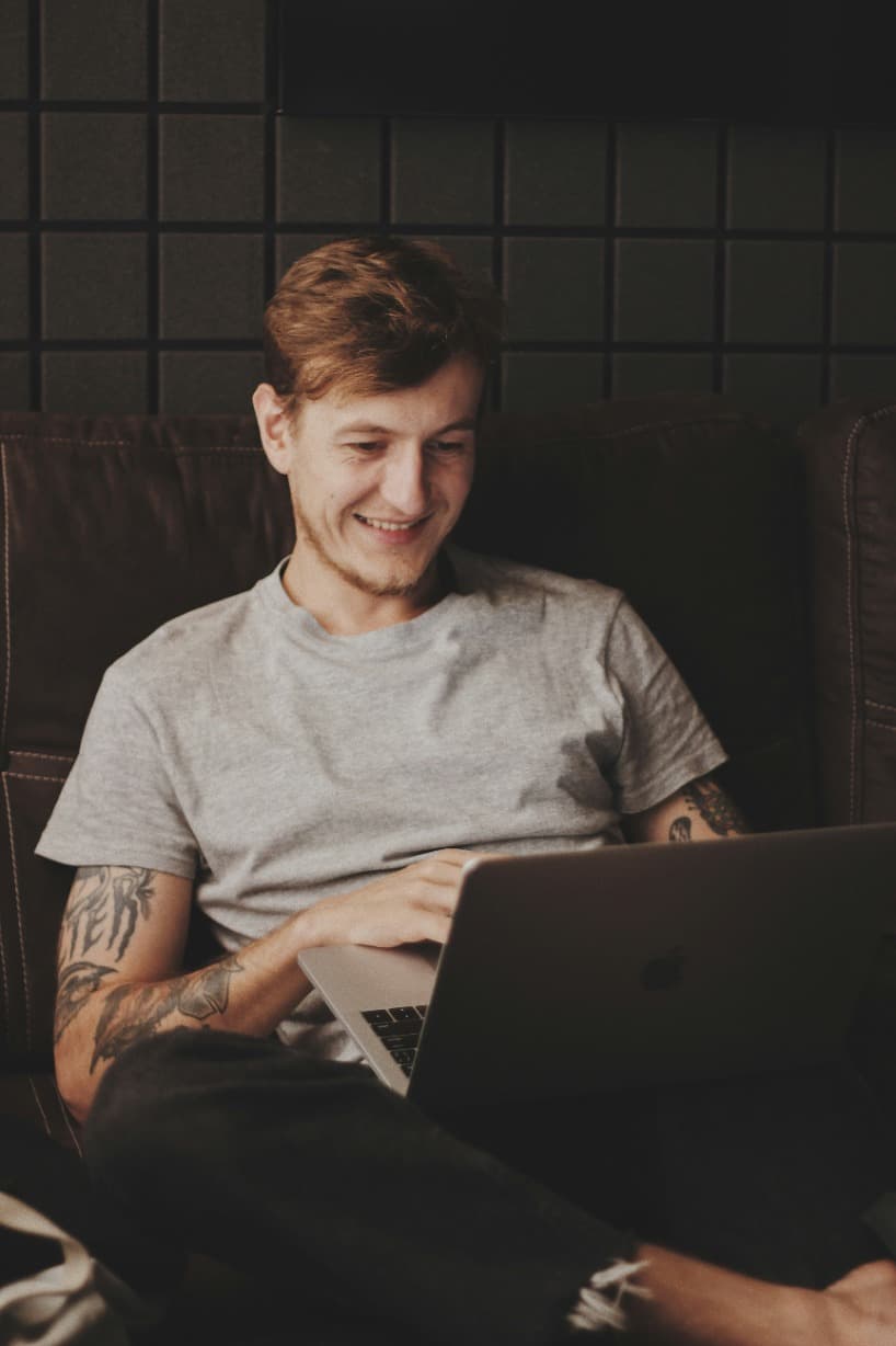 White Man Grinning At Laptop